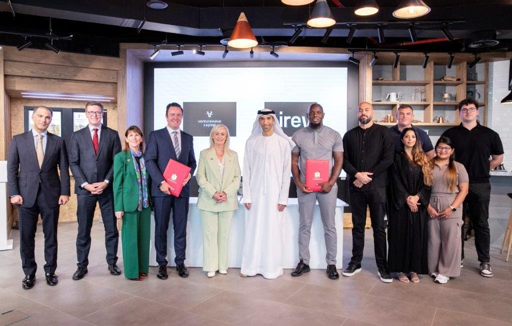 Group photo at AIREV and Venturewave Capital investment ceremony, featuring leadership and team members from both organizations, along with Irish and UAE government officials, standing in front of co-branded logos.